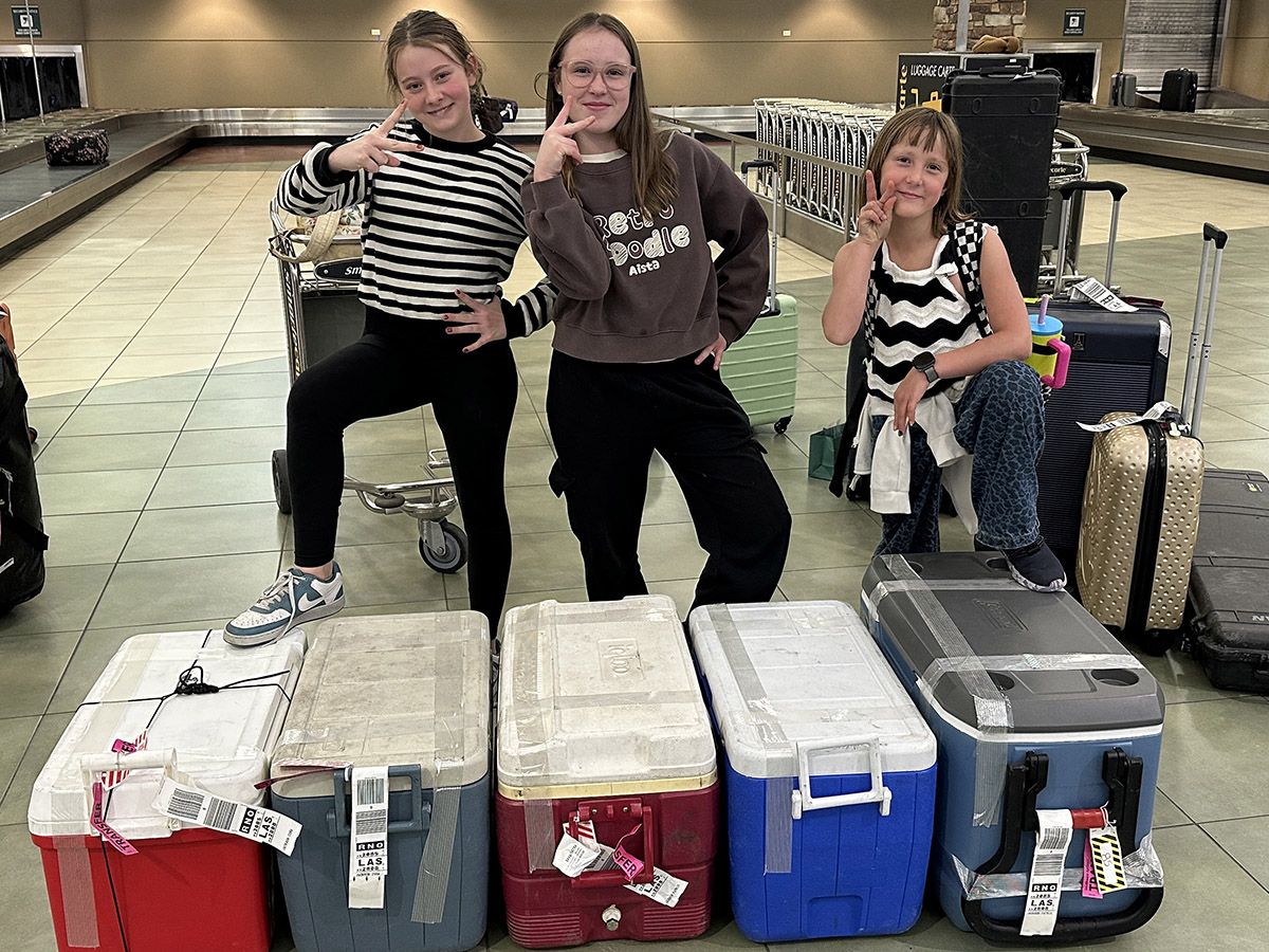 Three young hunters at the airport with their coolers of deer meat Three young hunters at the airport with their coolers of deer meat